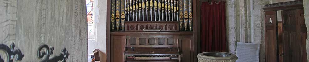 The entrance to Hatley St George church, Hatley St George, Cambridgeshire / 13th September 2018. Facing you are the 1878 Bevington organ and 19th century font to the right. Above the organ are some of the St. George family shields which are a feature of the church