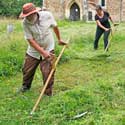 Scything in St Denis' churchyard, East Hatley, Cambridgeshire - 11-7-23 - Richard Brown, leader, with volunteers from Gamlingay and Hatley. Photo / Peter Mann.